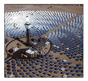 Photo of a black and white tower surrounded by several rows of square, metallic panels that are pointing  towards the tower.