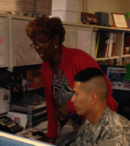 AW2 Career Coordinator Roberta Berry and Staff Sgt. Gilberto Guiling conference call with a Veteran to coordinate his enrollment in a PhD program.