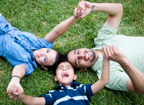 smiling parents and child join hands