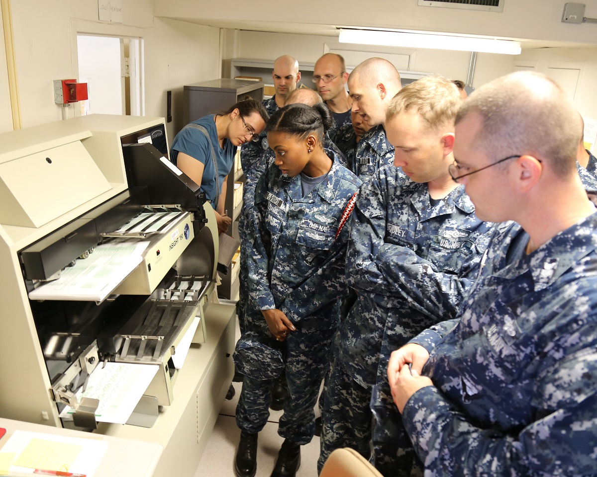 PENSACOLA, Fla. (Aug. 29, 2016) A group of 15 prospective Chief Petty Officers from the Center for Information Warfare Training watch advancement exams being scanned during their tour of the Navy Advancement Center at Saufley Field in Pensacola.  The Chief Selectees received in-depth briefs on the advancement process during their visit.  U.S. Navy photo by Ed Barker/Released 

