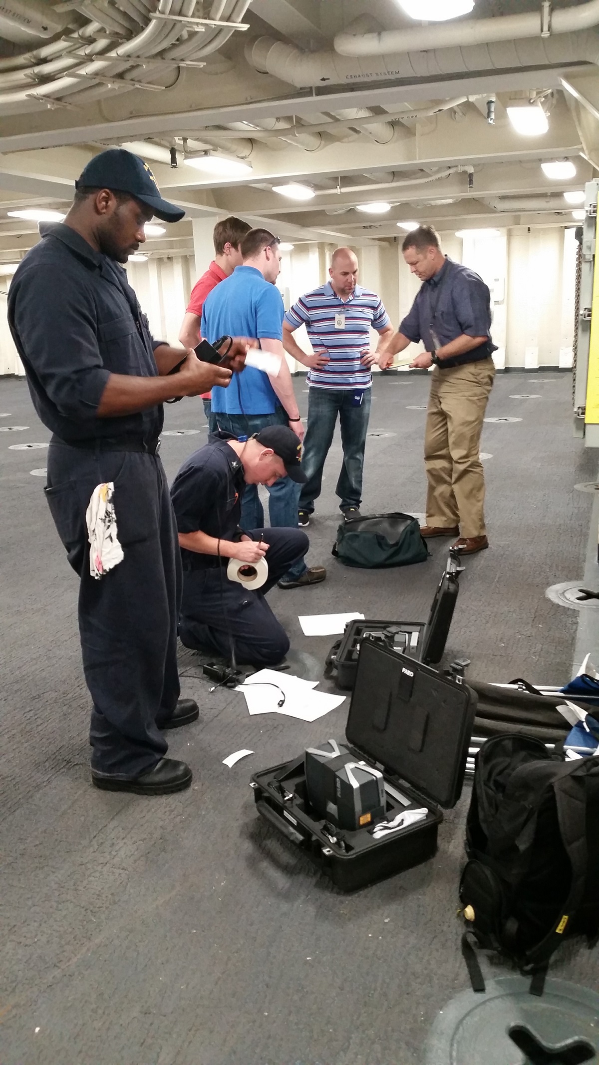 USS Arlington (LPD-24) crew members evaluate scanning equipment prior to use, while Naval Surface Warfare Center personnel from Panama City, Florida, and Philadelphia, Pennsylvania scientists and engineers discuss the scan validation measurements May 27, 2015 in Norfolk, Virginia. Photo by Tyson Kackley/NSWC PCD