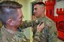 Col. Jon Chytka, left, commander, U.S. Army Corps of Engineers - Transatlantic Afghanistan District, pins the Combat Action Badge on Spec. Andrew Rinkenberger for his actions under fire in Afghanistan.