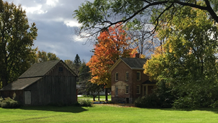 House and barn on a grass field