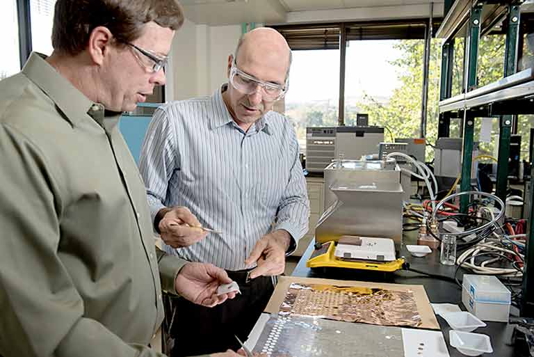 NREL researchers, Matthew Keyser and Ahmad Pesaran with the battery internal short-circuit device in the lab.