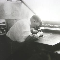 Black and white photo showing an engraver creating a contour plate for a topographic map