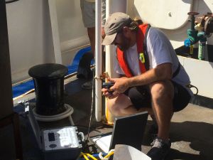 Joel from FWC checks the connection to an acoustic receiver that has just been dropped to the sea floor.