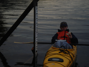 ENS Micki Ream reads measurements from the tide staff during higher tide. 