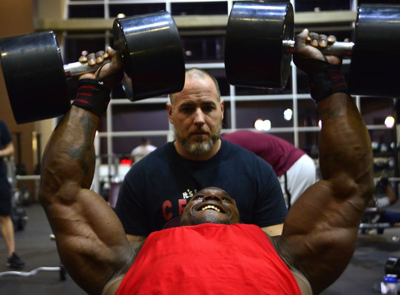 Tech. Sgt. David, a 432nd Maintenance Group contract officer representative, performs chest-fly repetitions while his trainer, Derrick Chandler, motivates him during a workout Dec. 4, 2015, at Nellis Air Force Base, Nev. David recently attained his International Federation of Bodybuilding and Fitness professional card, which allows him to compete in professional bodybuilding competitions. (U.S. Air Force photo/Airman 1st Class Christian Clausen)