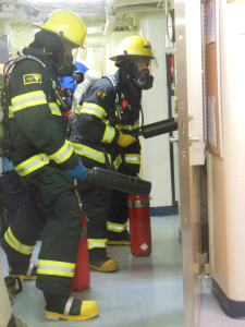 AB Wright and ENS McKay practicing fighting the fire with all their gear on.