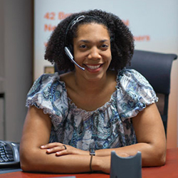 Smiling woman with a phone headset waiting at a desk