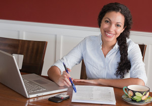 A busy woman working at a laptop.