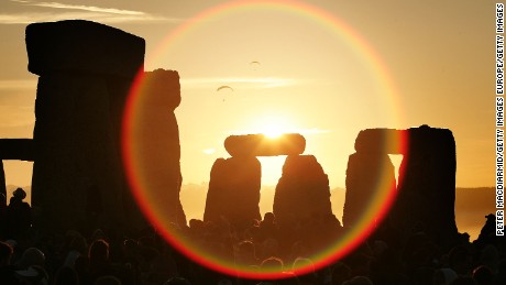 WILTSHIRE, UNITED KINGDOM - JUNE 21:  People watch the midsummer sun as it rises over the megalithic monument of Stonehenge on June 21, 2005 on Salisbury Plain, England. Crowds gathered at the ancient stone circle to celebrate the Summer Solstice; the longest day of the year in the Northern Hemisphere.  (Photo by Peter Macdiarmid/Getty Images)