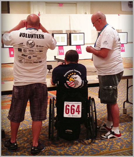 Photo of Veteran and Volunteers participating in an air rifle event
