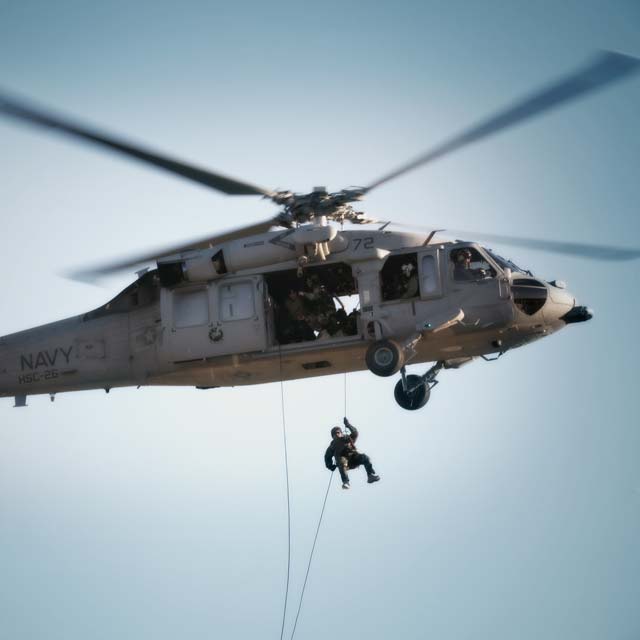 US Navy servicemember jumps from aircraft during mission.