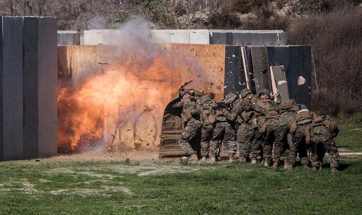 Marines shield themselves from a detonated explosive charge during a breaching exercise. Modern body armor better protects warfighters against shrapnel from explosive blasts. However, they still face the resulting blast pressure and shock wave that could cause traumatic brain injury. (U.S. Marine Corps photo by Sgt. Emmanuel Ramos)