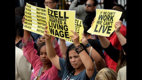 Members of the &#39;Black Lives Matter&#39; group protest the death of Ezell Ford as the Los Angeles Mayor Eric Garcetti signs into law an ordinance raising the minimum wage to  USD 15 an hour by 2020, in Los Angeles, California on June 13, 2015.  Los Angeles is the first major city to sign the ordinance and the increase will be USD 6 from the current  USD 9 per hour.        AFP PHOTO / MARK RALSTON        (Photo credit should read MARK RALSTON/AFP/Getty Images)