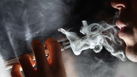 LONDON, ENGLAND - AUGUST 27:  In this photo illustration, a man smokes an E-Cigarette at the V-Revolution E-Cigarette shop in Covent Garden on August 27, 2014 in London, England. The Department of Health have ruled out the outlawing of &#39;e-cigs&#39; in enclosed spaces in England, despite calls by WHO, The World Health Organisation to do so. WHO have recommended a ban on indoor smoking of e-cigs as part of tougher regulation of products dangerous to children.  (Photo by Dan Kitwood/Getty Images)