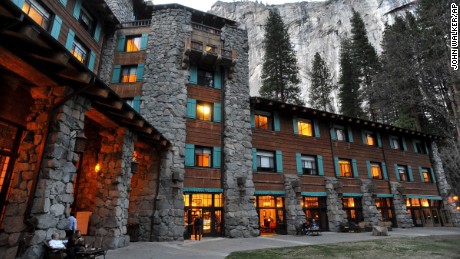 File - In this March 24, 2014 file photo, the historic Ahwahnee Hotel is lit up as dusk falls over Yosemite National Park, Calif. A new concessionaire takes over Tuesday at the park and many of the landmark places will have name changes at least temporarily because the old concessionaire lays claim to the names. The famed Ahwahnee Hotel is set to become the Majestic Yosemite Hotel. (John Walker/Fresno Bee via AP, File)