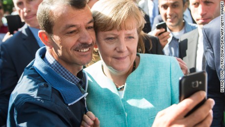 An asylum seeker takes a selfie with German Chancellor Angela Merkel in Berlin on September 10, 2015.