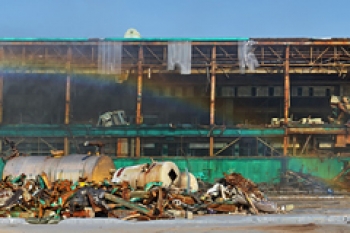 A panoramic view of the east end of the C-410 complex shows a rainbow forming as sunlight passes through vapor from misting machines used to suppress dust.