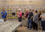 Tour guide Steve Christmas of Fluor Federal Services discusses the process to enrich uranium as participants gather in the former plant’s main control room. (Photo by Will Evans)