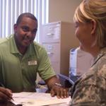 Man at desk talking with a service member