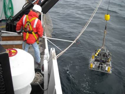 SeaBoss being deployed. It is suspended from the J-Frame and swung outboard. Tending the SeaBoss can be hazardous so crew members are tethered to the deck.
