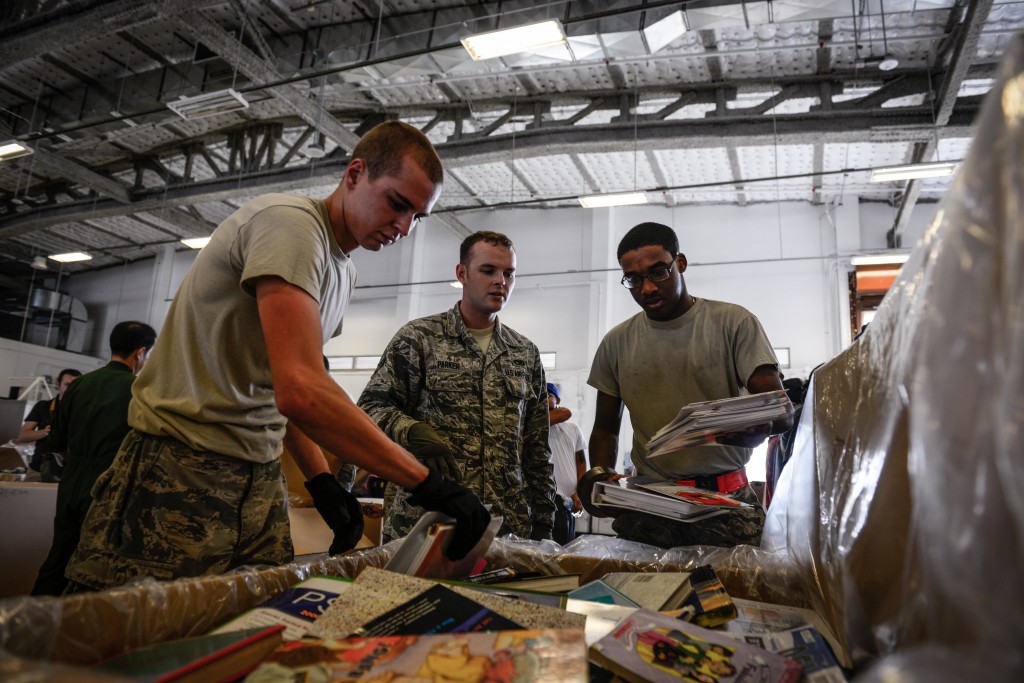 Airmen pack donated books for Operation Christmas Drop Dec. 5, 2015, at Andersen Air Force Base, Guam. Crews built 100 bundles with donations such as non-perishable food items, clothing, fishing supplies, tools, toys and other various goods that intend to bring holiday cheer to remote Pacific Islanders. Operation Christmas Drop is a humanitarian aid/disaster relief training event where C-130 aircrews perform LCLA airdrops on unsurveyed drop zones while providing critical supplies to 56 islands throughout the Commonwealth of the Northern Marianas, Federated States of Micronesia and Republic of Palau. (U.S. Air Force photo by Staff Sgt. Alexander W. Riedel/Released)
