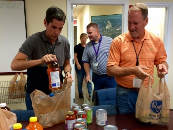 Front, left to right: Tyler Hicks and Rob Swett from DOEâ€™s Portsmouth/Paducah Project Office in Lexington pack non-perishable items for donation to local food pantries.