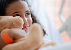 little girl smiling, holding teddy bear