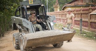 SVAY RIENG PROVINCE, Cambodia: Equipment Operator 3rd Class Charles Luthor, right, assigned to Naval Mobile Construction Battalion (NMCB) 5, ground-guides for Engineering Aid 2nd Class Viktoria Thompson to get a load of at the Sromo Primary School in Svay Rieng Province, Cambodia.  (U.S. Navy photo by Mass Communication Specialist 1st Class Benjamin A. Lewis/Released)