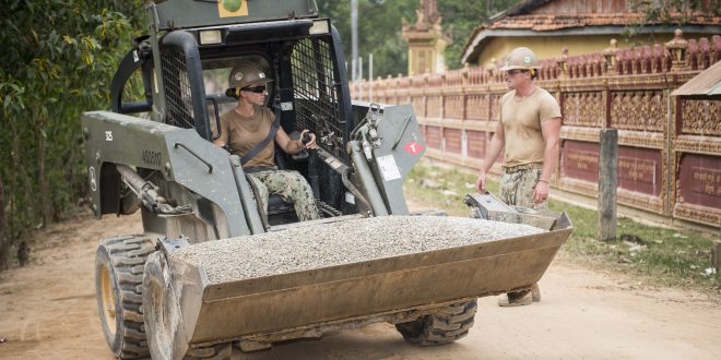 SVAY RIENG PROVINCE, Cambodia: Equipment Operator 3rd Class Charles Luthor, right, assigned to Naval Mobile Construction Battalion (NMCB) 5, ground-guides for Engineering Aid 2nd Class Viktoria Thompson to get a load of at the Sromo Primary School in Svay Rieng Province, Cambodia.  (U.S. Navy photo by Mass Communication Specialist 1st Class Benjamin A. Lewis/Released)