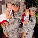 Service members holding children