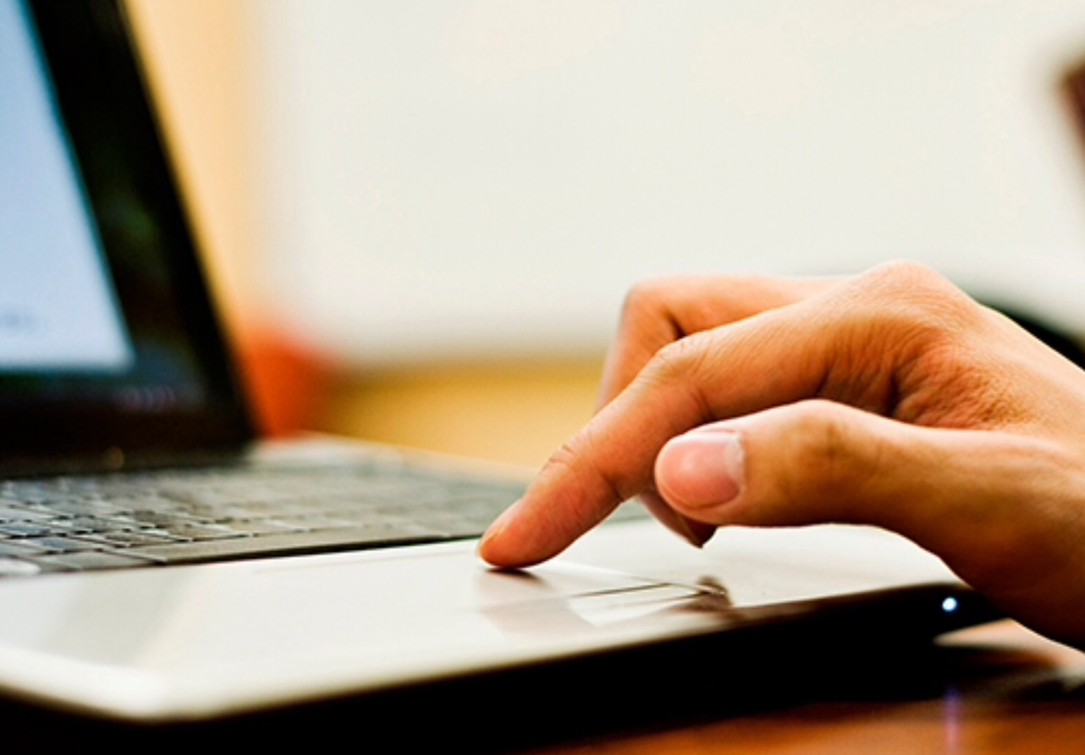 a picture of a hand on a laptop keyboard.