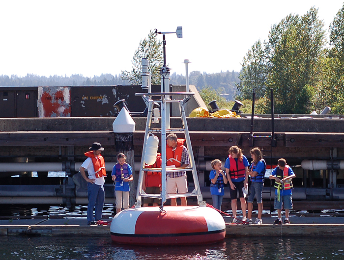 In July 2007, NOAA partnered with Washington Sea Grant and the University of Washington Joint Institute for the Study of Atmosphere and Oceans to host the fifth annual NOAA Science Camp in Seattle.  During the week-long camp, 53 middle-school-aged campers worked on a hypothetical fish kill in the Puget Sound and learned about NOAA science through hands-on activities.  At the end of the week, the campers applied the knowledge they had learned during the activities to investigate the cause and impacts of the fish kill, and presented their conclusions to the scientists, families and friends. 

Joining the WSG camp staff were scientists from NOAA Fisheries Service, NOAA Ocean Service, National Weather Service, NOAA Research, NOAA Office of Marine and Aviation Operations, and JISAO. 

Left to right: Curran Fey and Dr. Nick Bond from JISAO show campers a TAO buoy used to collect oceanographic data. Photo by Megan Burbank, WSG Staff Photographer.
