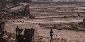 A girl with an Iraqi flag walks near her home in Qayyara, Iraq, Nov. 12, 2016. The military campaign to retake Mosul, Iraq’s second-largest city, has displaced nearly 70,000 Iraqis. More civilians than ever are taking the risk of evacuation, hoping to find help if they can make it past the militants’ gun range. (Sergey Ponomarev/The New York Times)