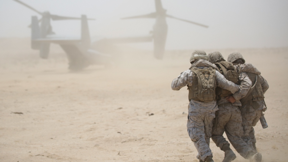 Sgt. Charles Retter, motor transport maintenance chief, and Lance Cpl. Gustavo Arellano, radio operator, with 4th Medical Battalion, 4th Marine Logistics Group, Marine Forces Reserve, carry a Marine to an aircraft in a casualty simulation exercise during Integrated Training Exercise 4-15 aboard Marine Corps Air Ground Combat Center Twentynine Palms, Calif., June 20, 2015. During the exercise, Marines and Sailors worked together to perform a casualty rescue, in which victims were extracted or boarded onto an aircraft and transported to a field medical station. U.S Marine Corps photo by Cpl. Ian Ferro.