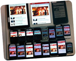 Many smartphones and tablets on a table displaying the same app.