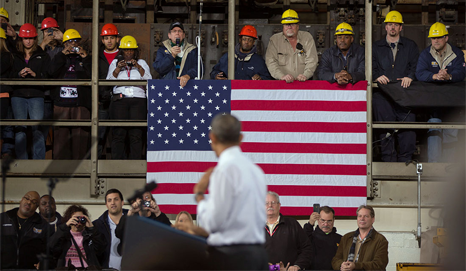 President Obama listens to questions from workers at an event