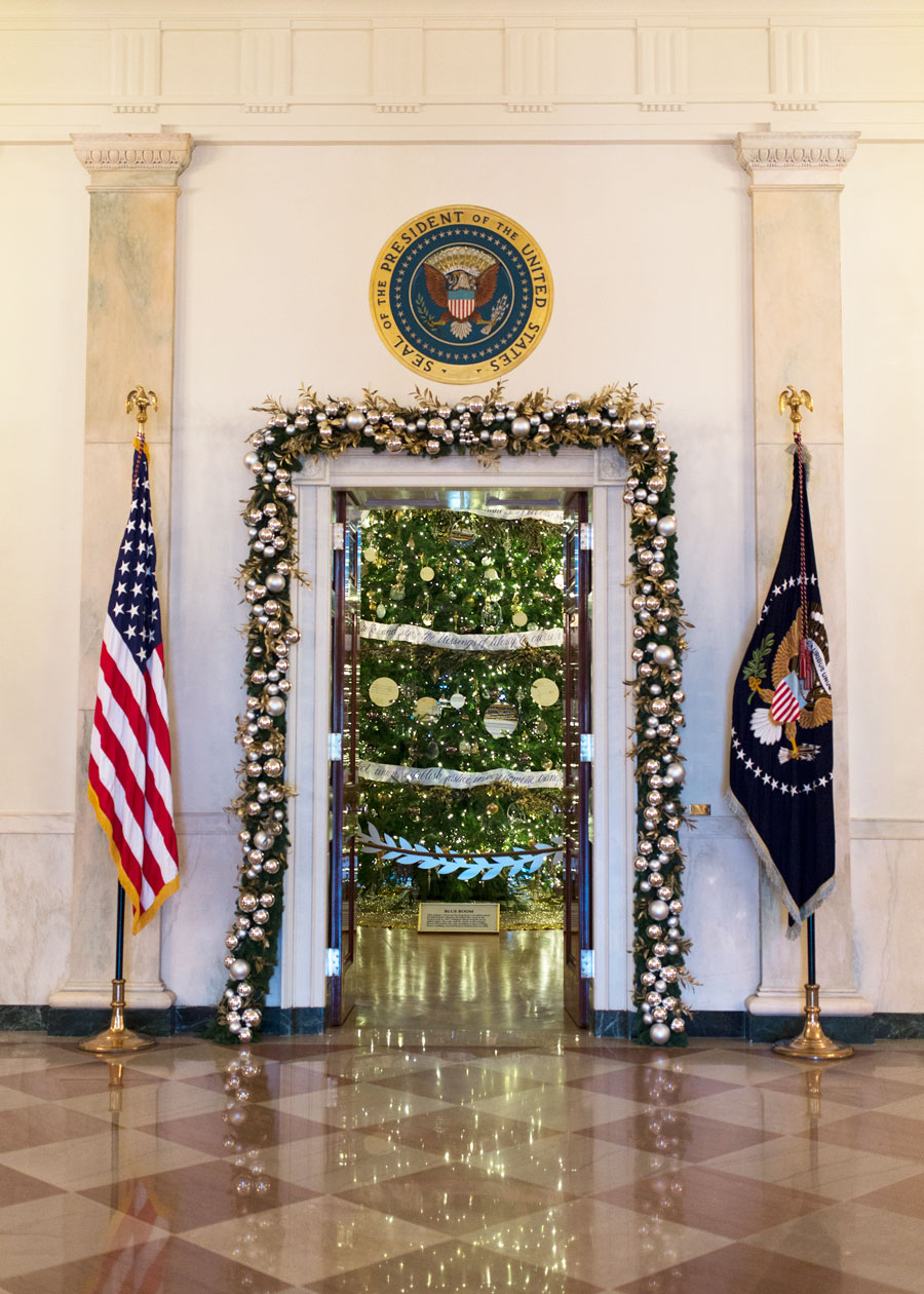 Door leading to the Blue Room is decorated with garland, with a sneak peek of the Christmas Tree.