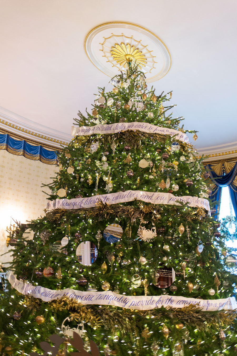 This year's iconic Blue Room Christmas Tree celebrates "We the People," as it is trimmed with ribbon garland featuring the Preamble to the United States Constitution.