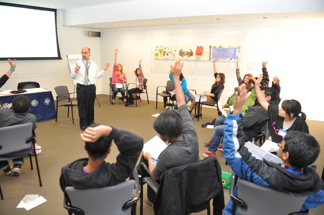 Students from Eastern Middle School in Maryland raise their hands to answer a question posed by USIP's David Smith (center).