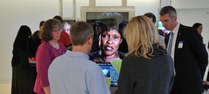 Four teachers gather around the Witnesses to Peacebuilding stations to watch video interviews with Betty Bigombe and other peacebuilders.