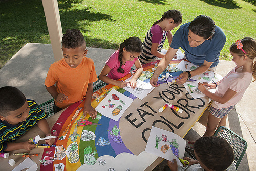 Kids and a man drawing on the Eat Your Colors theme