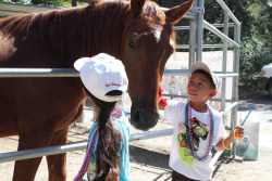 A boy and a girl petting a horse. Photo by BLM.