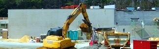 photograph of a construction site with a dump truck and bucket truck working away