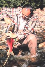 Fisherman holding a salmon he just caught.