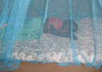 An image of a child sleeping under a bed net.