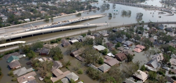 This aerial photo of New Orleans from August 29, 2005, shows a flooded neighborhood with a roadway going down into flood waters. Photo courtesy of FEMA/Jocelyn Augustino