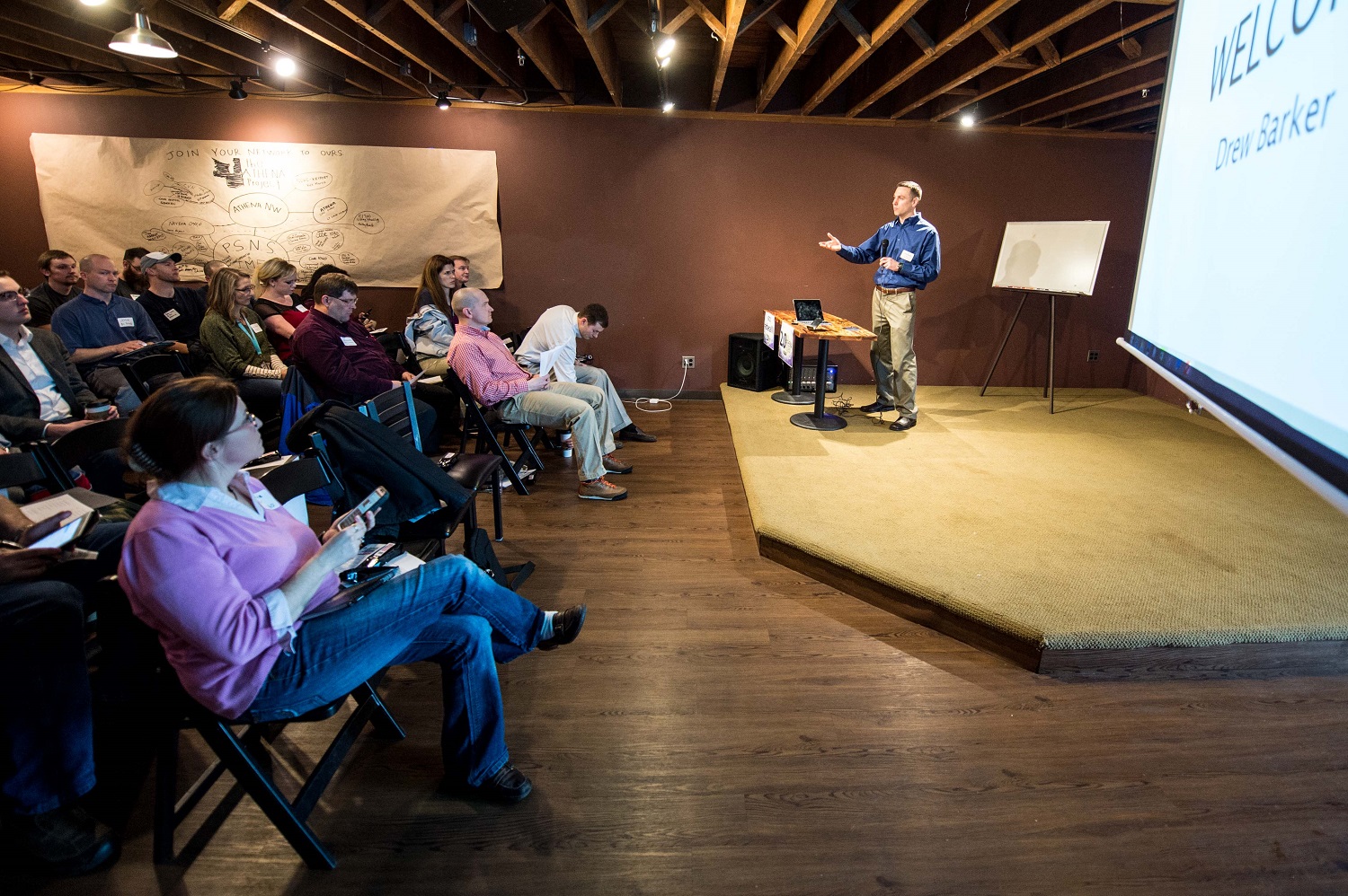 BREMERTON, Wash. (Feb. 27, 2015) Lt. Cmdr. Drew Barker, from Kennewick, Wash., assigned to the Nimitz-class aircraft carrier USS John C. Stennis (CVN 74), addresses a crowd gathered for Athena Project 2.0. The Athena Project creates a platform for Sailors to pitch innovative ideas to improve their command or the Navy in an open forum to fellow Sailors as well as leaders of industry, academics, and government. U.S. Navy photo by Mass Communication Specialist 3rd Class Seth Coulter 